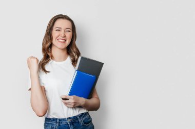 Öğrenci kız zafer işareti gösteriyor. Evet, zafer işareti. Beyaz arka planda izole edilmiş. kopyalama alanı. Öğrenci değişim yarışmasını kazandı.