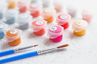 Paints, brushes and canvas set for painting by numbers activity. Hobby and leisure activity. Home drawing and learning.world art day