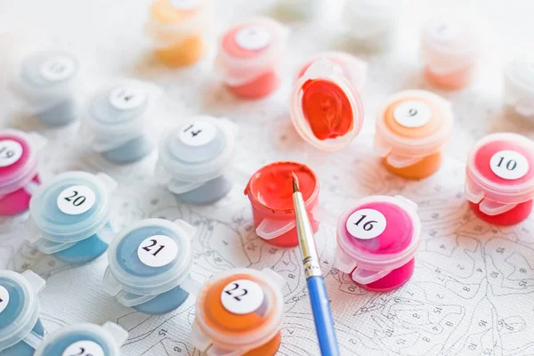 Paints, brushes and canvas set for painting by numbers activity. Hobby and leisure activity. Home drawing and learning.world art day