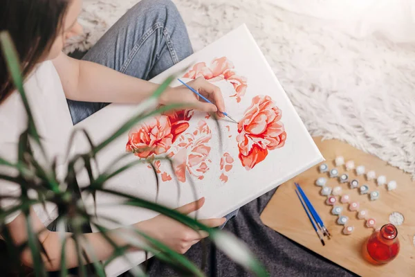 painting by numbers. Young woman drawing picture with acrylic paints on canvas, enjoying creative leisure activities. top view