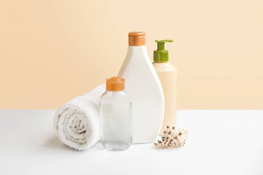 Body and face care. Micellar water jar, body lotion, white towel depilatory razor copy space