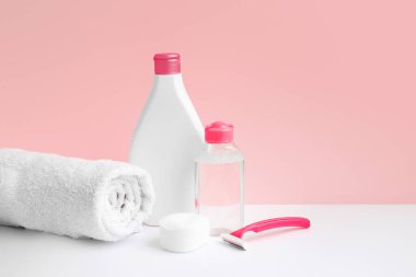 Hygiene and body care. Micellar water body lotion, towel, razor, cotton pads on pink background, spa and female treatments. Epilation concept