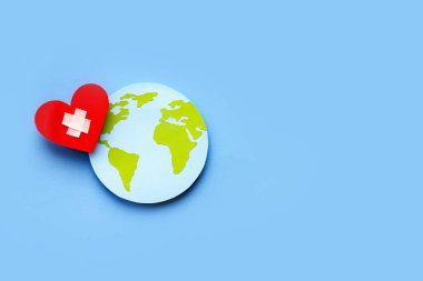 Dünya Sağlık Günü konsepti, kağıt küre ve mavi arka planda kırmızı kalp. Boşluğu kopyala