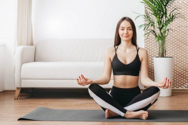 Kafkasyalı genç kadın evde sabah yogası yapıyor. Ruh ve beden için meditasyon. sağlıklı yaşam tarzı konsepti. Boşluğu kopyala