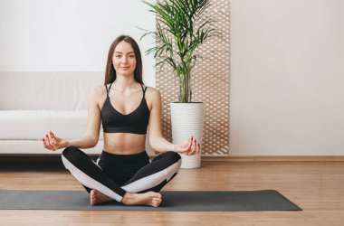Kafkasyalı genç kadın evde sabah yogası yapıyor. Ruh ve beden için meditasyon. sağlıklı yaşam tarzı konsepti. Boşluğu kopyala