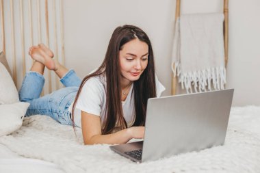 Evde dizüstü bilgisayarla çalışan ve ekrana bakan bir kızın portresini yakından çek. Genç kadın metin yazarı, uzaktan çalışma, serbest yazarlık konsepti