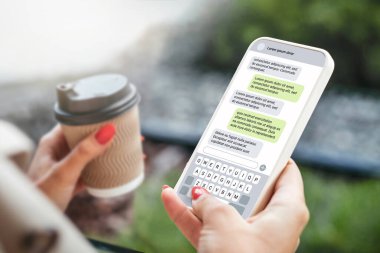 Dışarıda telefonla mesajlaşan bir kadın. Akıllı telefonlu bir mesaj. Mesajlaşma sohbeti. Arkadaşla sohbet etmek.