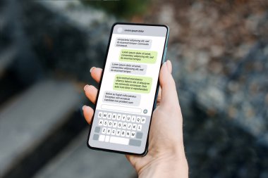 Dışarıda telefonla mesajlaşan bir kadın. Akıllı telefonlu bir mesaj. Mesajlaşma sohbeti. Arkadaşla sohbet etmek.