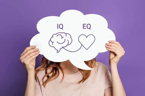 IQ Eq konsepti. Elinde beyin ve kalp çizen bir konuşma balonu posteri tutan kız. IQ zeka seviyesi ve EQ duygusal zeka kavramı