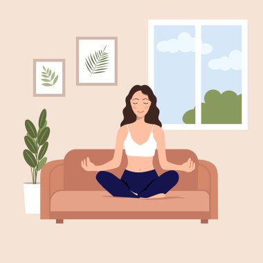 Evde yoga. Kız evinde kanepede oturur ve pencerenin ve tabloların arka planına karşı meditasyon yapar. Nefes egzersizleri, yoga, meditasyon konsepti.