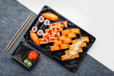 Plastik tek kullanımlık tabaklarda suşi, Nora, beyaz arka planda wasabi.