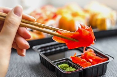 Kızıl ve bambu çubuklu kızıl bir kadın eli.