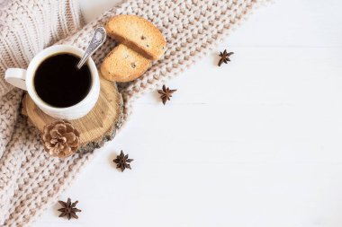 Bir fincan kahve, kazak, yıldız anason, beyaz ahşap arka planda tatlı kahve, fotokopi alanı, kış yatağı. Beyaz ahşap Noel arkaplan görünümü, metin için boşluk