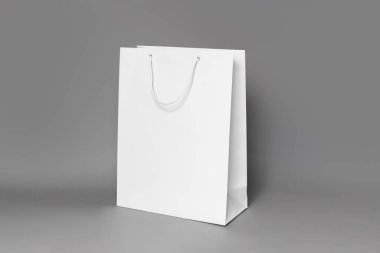Beyaz alışveriş çantasının modeli koyu gri kağıt arka planda izole edilmiş. yan görünüm