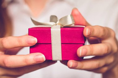 Elinde hediye olan kırmızı bir kutu tutan kadın eller. Doğum günü kavramı