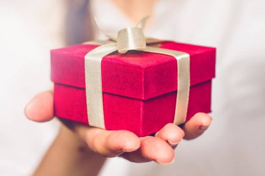 Elinde hediye olan kırmızı bir kutu tutan kadın eller. Doğum günü kavramı