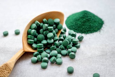 Tabletlerde yeşil yosun spirulinası ve çuval bezinde pudra. Sebze proteini
