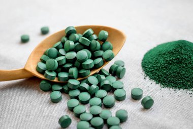 Haplar ve deniz yosunu sarmaşığı tozu, tahta kaşıkta klorella. Bitki proteinli vejetaryen süper yiyecekler. Deniz vitaminleri, mineraller