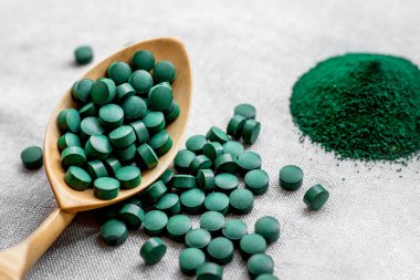 Tabletlerde yeşil yosun spirulinası ve çuval bezinde pudra. Sebze proteini