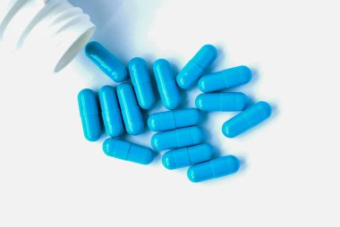 Mavi kapsüller, beyaz arka planda izole edilmiş haplar. Beyaz kavanozdaki kapsüller. Vitaminler, kadın sağlığı için besin takviyeleri