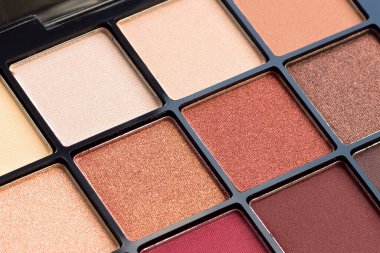 Kahverengi tonlarda bir palet göz farı, mat ve ışıltılı kırmızı göz farı, yakın çekim, makro. Sonbahar göz farı paleti, kadın dekoratif kozmetik ürünleri