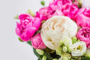 Şapka kutusunda çiçek aranjmanı. Şakayık buketi, coşku, pembe bir kutuda gül, beyaz bir arka planda vaha.