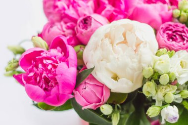 Şapka kutusunda çiçek aranjmanı. Şakayık buketi, coşku, pembe bir kutuda gül, beyaz bir arka planda vaha.