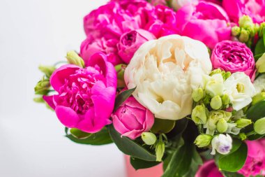 Şapka kutusunda çiçek aranjmanı. Şakayık buketi, coşku, pembe bir kutuda gül, beyaz bir arka planda vaha.