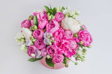 Şapka kutusunda çiçek aranjmanı. Şakayık buketi, coşku, pembe bir kutuda gül, beyaz bir arka planda vaha.