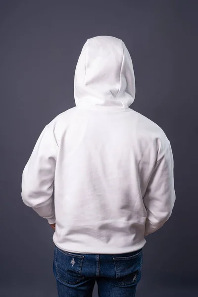 White hoodie back side. Man with the hood on from back side on gray background. Empty copyspace