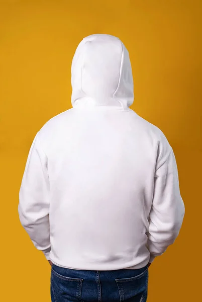 Casual sporty white hoodie jumper back side. Man with the hood on from back side on gray background. Empty copyspace