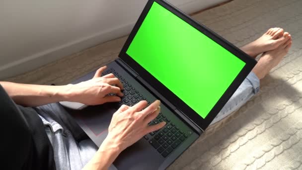 女性使用带有彩色键绿色屏幕的笔记本电脑 在家上网购物 蓝色牛仔裤和赤脚 录像镜头 — 图库视频影像
