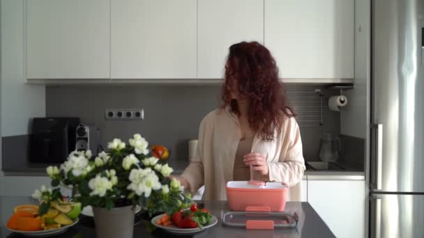 Kobieta Wkładająca Pudełka Ciasteczka Migdały Jagody Różowy Plastikowy Pojemnik Przygotowywanie — Wideo stockowe