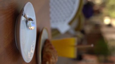 Kafe Summer Terrace 'ın dışındaki caddede boş bir fincan kahveyi bitirdim. Barcelona 'daki bir kafede kahvaltı yapan bir kadın. Dikey video görüntüleri  