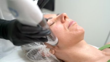Yaşlanma karşıtı kozmetik işleme yakından bakın Transdermal Mezoterapi ürün serumu güçlü hava basıncının etkisiyle deriye nüfuz eder. Güzellik uzmanının ofisindeki video görüntüleri. Rahatlamış hasta 