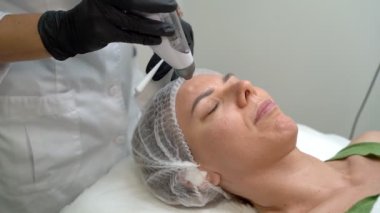 Yaşlanma karşıtı kozmetik cihaz prosedürünün videosunu kapat. Transdermal Mezoterapi ürün serumu güçlü hava basıncının etkisiyle deriye nüfuz eder. Güzellik uzmanının ofisindeki video görüntüleri.