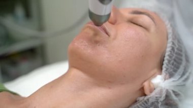 Yaşlanma karşıtı kozmetik prosedür Transdermal Mezoterapi ürün serumu güçlü hava basıncının etkisiyle deriye nüfuz eder. Güzellik uzmanının ofisindeki video görüntüleri. Çenenin alt yüzüyle çalış