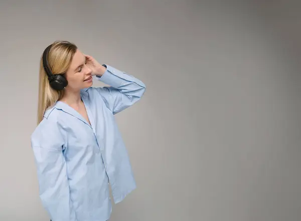 Blonde Smiling Woman Using Headphones Side Profile Listening Music Blue lizenzfreie Stockbilder