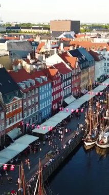 Kopenhag limanı panoramasına ait 360 derecelik hava aracı görüntüsü. Kamera hızla döner. Dikey video görüntüleri. Yumuşak günbatımı ışığı