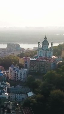 Ukrayna 'nın başkenti Kyiv' in hava görüntüleri. Kamera St. Andrew Kilisesi ve Andriivskyi Descent üzerinde uçuyor. Gün doğumu yumuşak yaz arkaplanı. Dikey video görüntüleri 