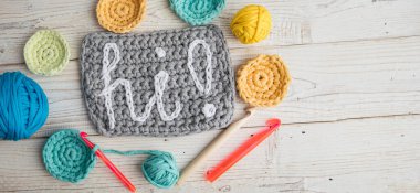 Örgü örmek üst görüş sözcüğünü oluşturur. Renkli yün yumakları mavi, sarı ve turuncu. El sanatları hobisi. Uzun yatay bayrak. Hoş geldin daveti