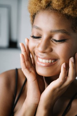 Gözleri kapalı güzel bir genç kadın. Rahatlamış sakin duygularla portreyi kapat. Cilt bakımı. Ellerinle yüzüne dokunuyorsun. Rüya gibi fantezi. 