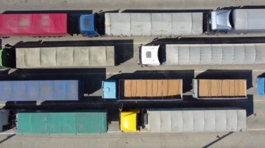 Terminalde kuyrukta bekleyen kamyonların üst görüntüsü. Traktörlerle kargo taşımacılığı. Otoparkta lojistik nakliye.