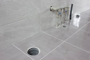 Yeni banyodaki su ve kanalizasyon boruları. Tesisat kurulacak bir yer.