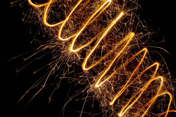 A spiral of light with sparks on a black background. Abstract sparks of fireworks