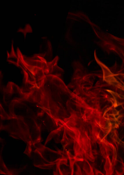 Blurred red flame in motion on a black background. Abstraction in red on black
