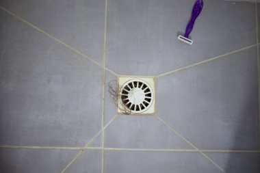 Duş zeminine saç ve jiletle lavabo, lavaboyu kadın saçlarıyla tıkamak.