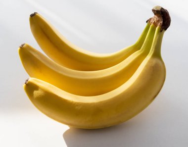 Beyaz bir masada muzlar, doğal ışıklandırma..