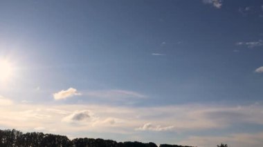 Orman ufkunun üzerinde günbatımında dinamik bulut oluşumu değişen ışık ve bulut hareketlerini yakalıyor.