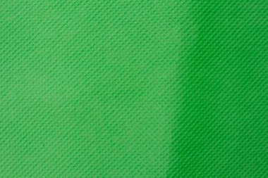 Yeşil arkaplan desenli bir yüzeye sahip, iki farklı yeşil tonu ayıran çapraz bir çizgi var.